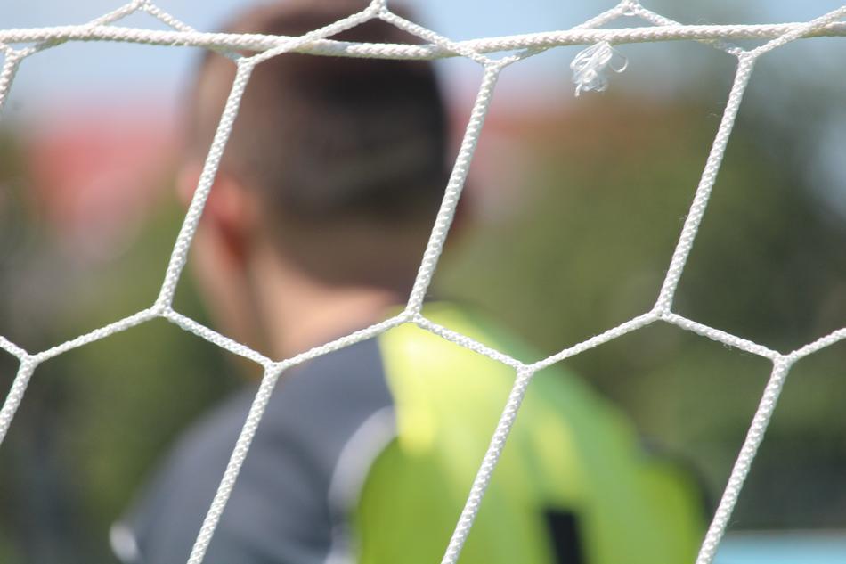goalkeeper behind the net in a blurred background