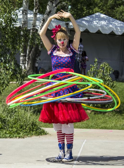 Person, dancing Hula with colorful rings, above the plants