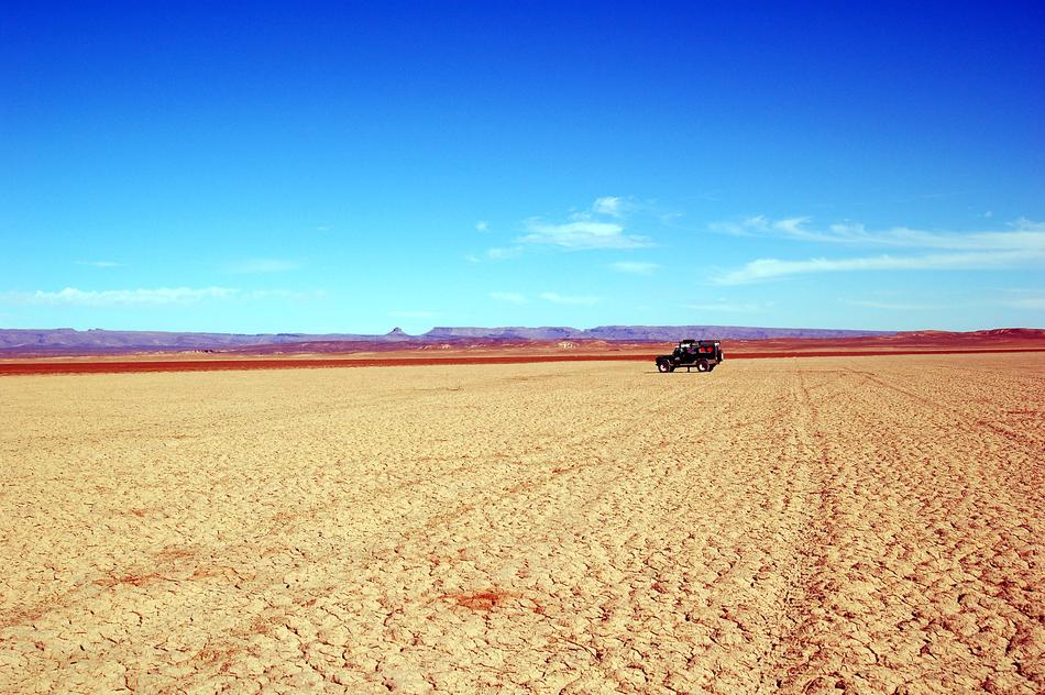 Beautiful landscape of the desert with a car, at blue sky with white clouds in Morocco, Africa