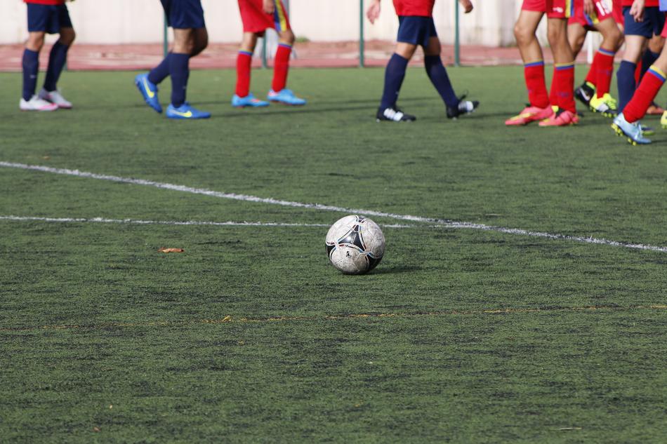 Football Ball green grass and legs