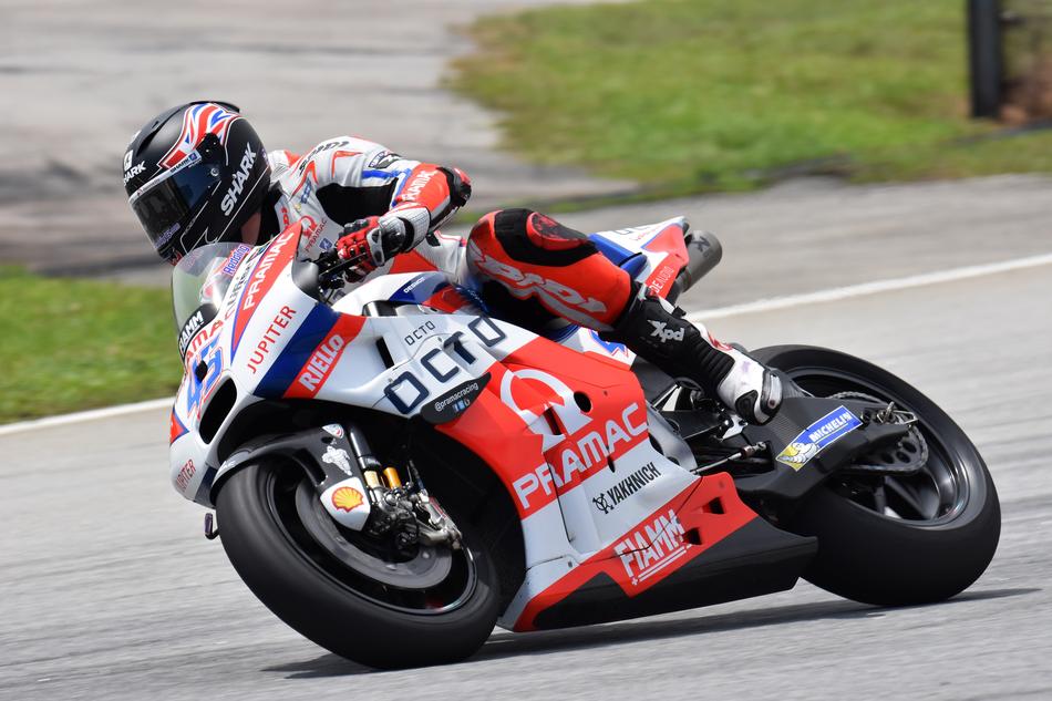 Motorcycle rider in the colorful, shiny equipment, on the road, in movement