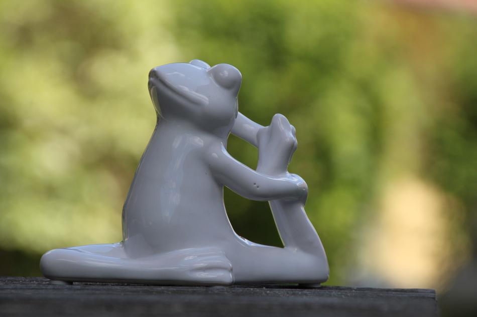 funny figurine in yoga pose on blurred background