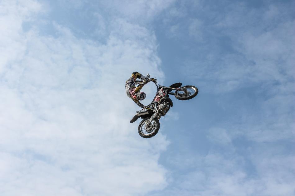 stunt motorcyclist high in the sky against the backdrop of clouds