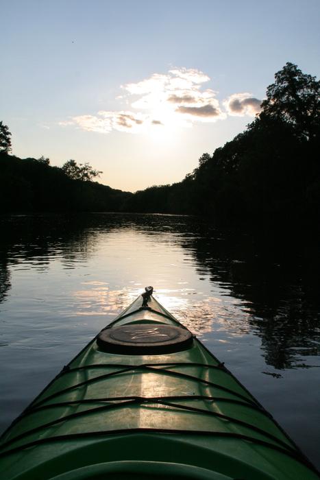 Beautiful landscape of the river, among the trees, on the view from the kayak, at beautiful and colorful sunset