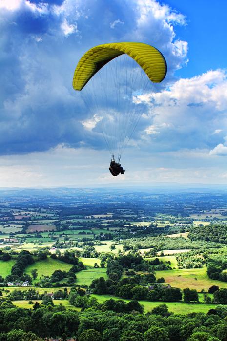 Paragliding over scenic countryside at summer