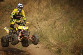 Person on the colorful quad in jump, on the enduro competition