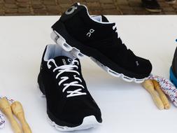 Pair of the black and white sports shoes, on the white surface