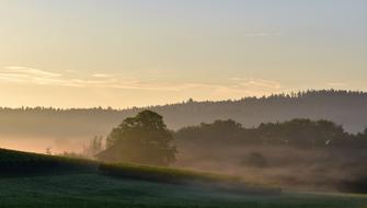 sunrise over countryside in fog