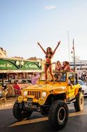 Woman in the yellow car, on the party, outdoors