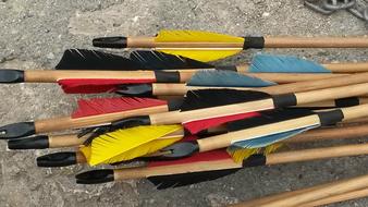 Beautiful wood arrows with colorful feathers and black ends, on the ground