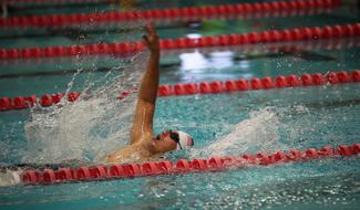 man on his back swims in the pool
