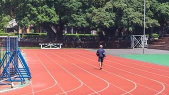 an athlete runs along a track in a stadium