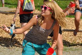 Blond girl with sunglasses, among the other people, doing sport, outdoors