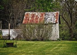 Old, rustic barn, on the green field, near the green trees in Ohio, USA