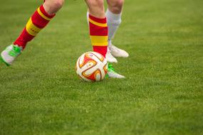 photo of footballers' feet and the ball on the field