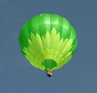 Flying green hot air balloon in the blue sky, in Greeley, Colorado, USA