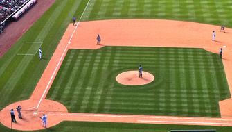 Players, on the beautiful, green and orange field, on the baseball competition in America