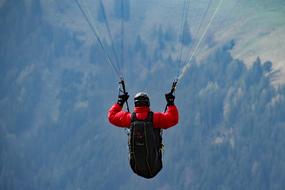 paragliding in the blue sky, back view