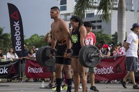 Man and woman, doing exercise with weights, on the competition