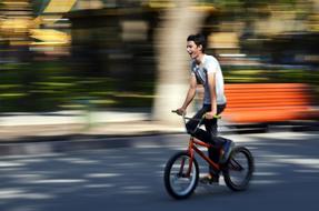 happy cyclist Speeding in city at Summer