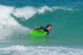 a man is gliding on a wave on a green board