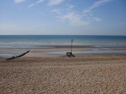 Beautiful landscape of the beach, with the boat near the blue, gradient water, under the blue sky with clouds