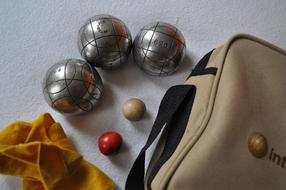 Shiny, metal boules, near the bag