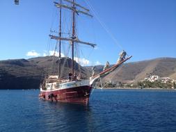 people on vintage sailing ship near coast