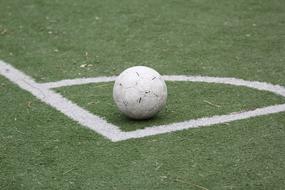 White football on the white corner, of the green grass field