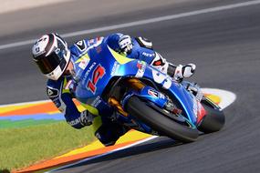 Colorful racer in helmet, riding on the motorcycle on the road, on the competition