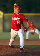 Baseball pitcher, in red and white uniform, on the field, on the game