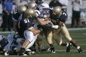 American football players in tackle, on the field, on the competition