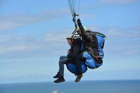 Paragliding, two persons in flight over sea