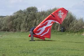 man with a big kite in the meadow