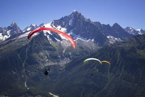 the paraglider flies over the mountains in the alps