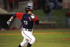 college baseball player is running across the field