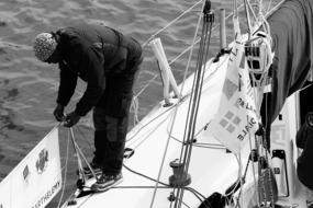 black and white, a man works on a sailing boat