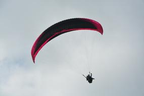 Paragliding with red parachute with two harnesses