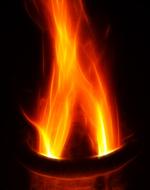 Close-up of the colorful, burning fire in the fireplace, among the darkness