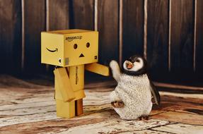 Cute Danbo and cute, colorful and beautiful penguin, near the wooden wall