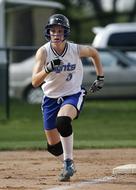 Female softball player in equipment, on the colorful field, on the competition