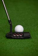 putter with a ball on an artificial golf course