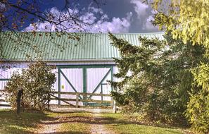 Bar with green roof and fence, and road, among the beautiful and colorful plants in Ohio, USA