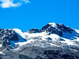 Beautiful, snowy Olympic Mountain in Whistler, Vancouver, in Canada, at blue sky, with white clouds on background