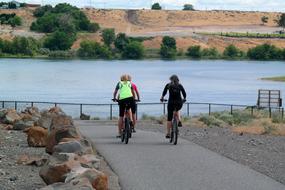 Bikers on the bike, near the beautiful water, among the colorful shore