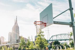 photo of a basketball hoop on the background of a railway bridge