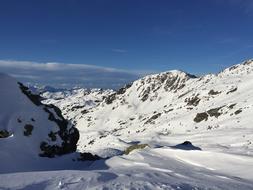 Beautiful snowy mountains, at blue sky with clouds on background, in light