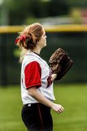 sportswoman in uniform with a glove on her hand in softball