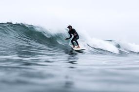surfer on an ocean wave on a cloudy day