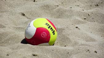 Close-up of the colorful beach volley ball on the sand, in sunlight
